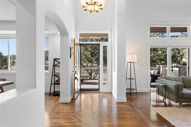 entryway with a high ceiling, baseboards, and a wealth of natural light