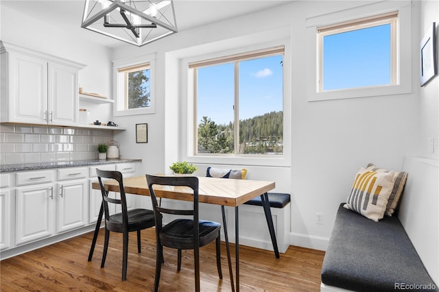 dining space with breakfast area, baseboards, and wood finished floors