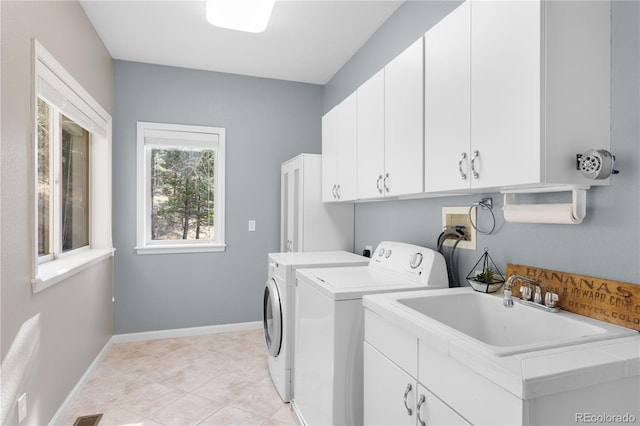 washroom featuring light tile patterned floors, baseboards, cabinet space, and washing machine and dryer