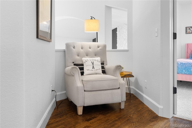 living area featuring baseboards and wood finished floors