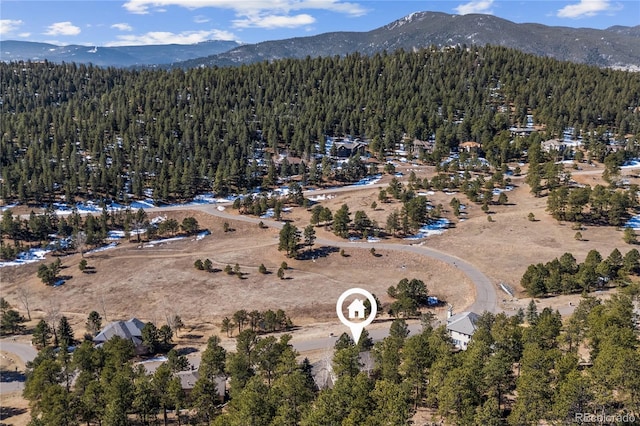 aerial view featuring a wooded view and a mountain view