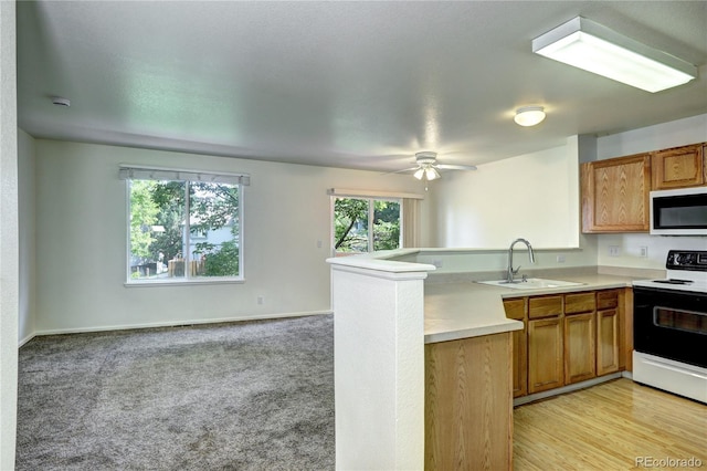 1997 E 102nd Cir, Thornton, CO 80229 - kitchen featuring white appliances, a peninsula, open floor plan, light countertops, and brown cabinets