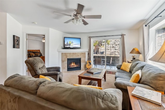 living area with a ceiling fan and a fireplace