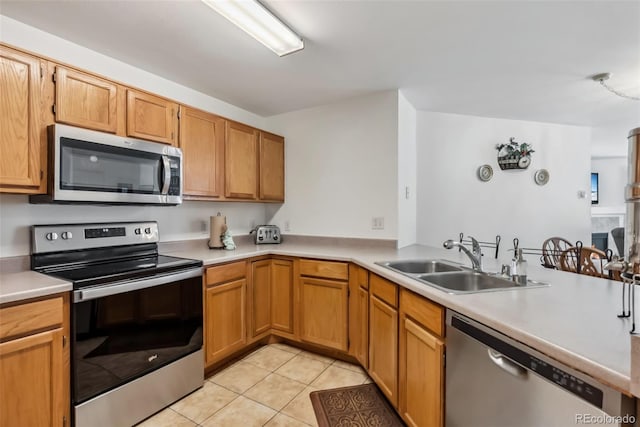 kitchen with light countertops, light tile patterned floors, stainless steel appliances, and a sink