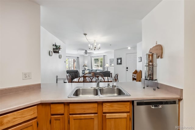 kitchen featuring stainless steel dishwasher, a sink, open floor plan, a chandelier, and light countertops