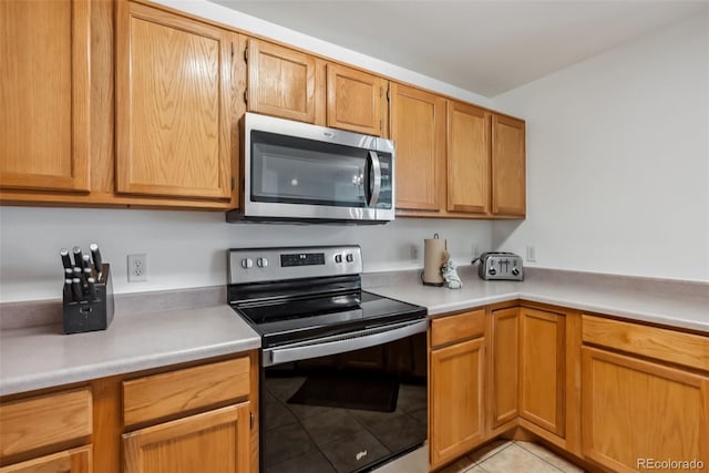kitchen with light tile patterned floors, light countertops, and stainless steel appliances