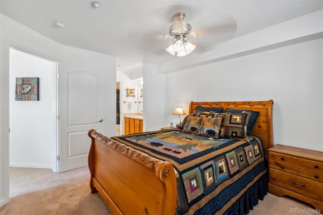 bedroom featuring light colored carpet, connected bathroom, baseboards, and a ceiling fan