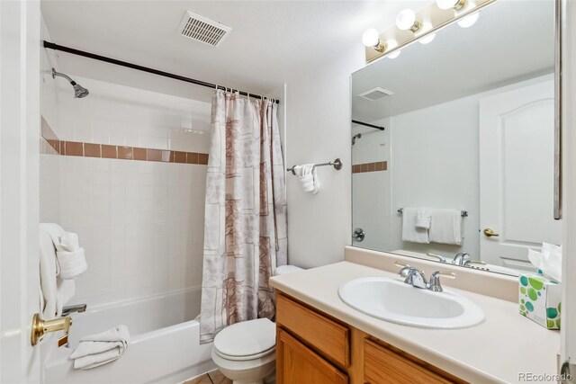 bathroom with vanity, toilet, visible vents, and shower / bath combo