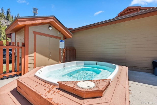 view of pool with a storage shed, an outdoor structure, and hot tub deck surround