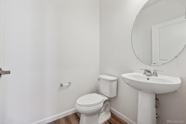 bathroom featuring sink, wood-type flooring, and toilet