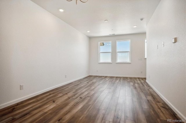 unfurnished room with dark hardwood / wood-style flooring and an inviting chandelier