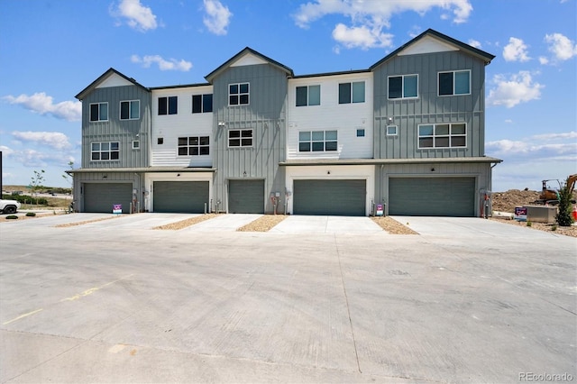 6940 Merseyside Ln, Castle Pines, CO 80108 - view of front of house with board and batten siding, an attached garage, and driveway