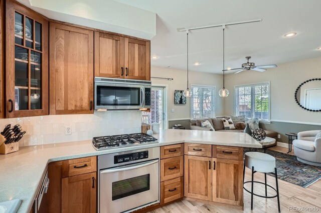 821 S High St, Denver, CO 80209 - kitchen with appliances with stainless steel finishes, open floor plan, a peninsula, track lighting, and recessed lighting