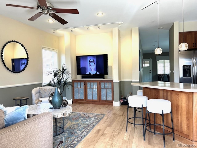 821 S High St, Denver, CO 80209 - living room with track lighting, a ceiling fan, light wood-style flooring, and baseboards