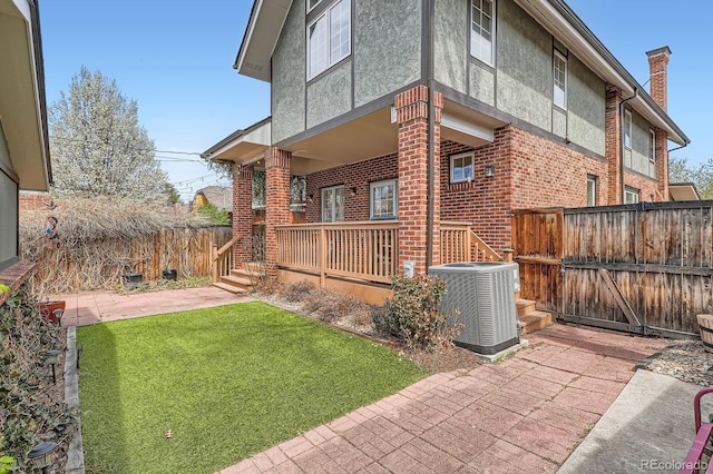 821 S High St, Denver, CO 80209 - view of side of home featuring cooling unit, brick siding, stucco siding, a porch, and a chimney