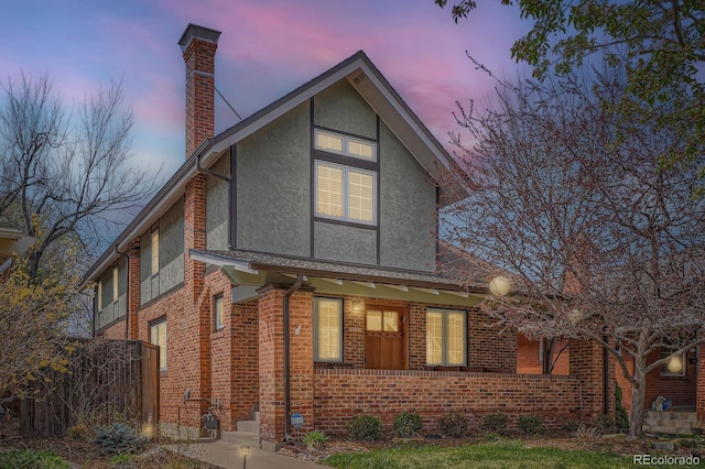 821 S High St, Denver, CO 80209 - view of front of home featuring a chimney, stucco siding, and brick siding