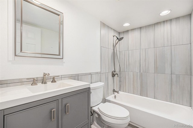 full bath featuring bathtub / shower combination, vanity, toilet, recessed lighting, and tile walls