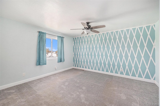 carpeted empty room with baseboards and ceiling fan