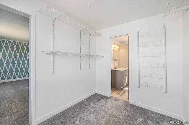 walk in closet with a sink and carpet flooring
