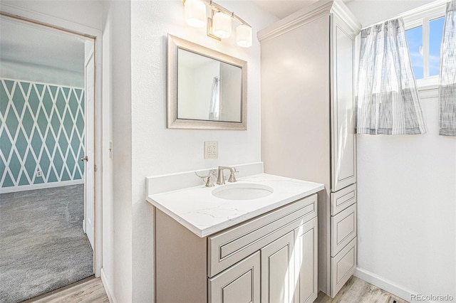bathroom featuring vanity, baseboards, and wood finished floors