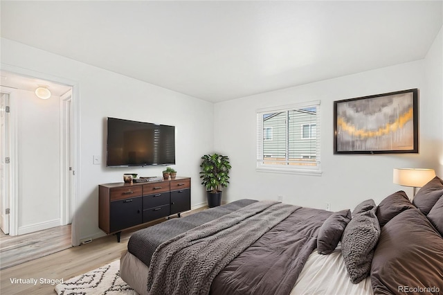 bedroom featuring baseboards and light wood-style flooring