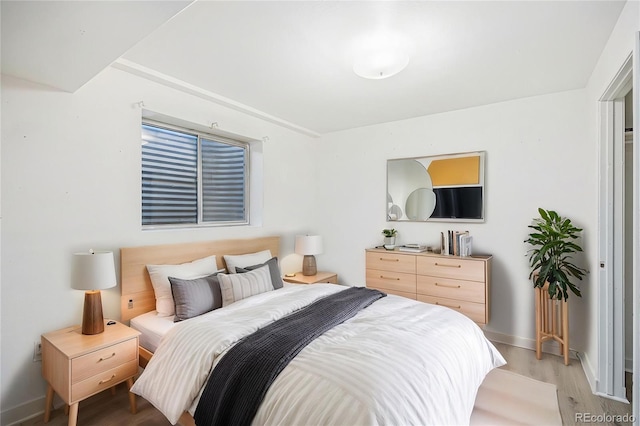 bedroom with baseboards and light wood finished floors