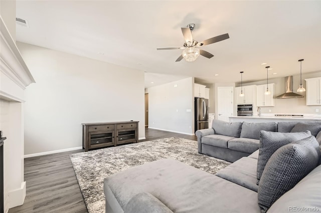 living room featuring a fireplace, dark hardwood / wood-style floors, and ceiling fan