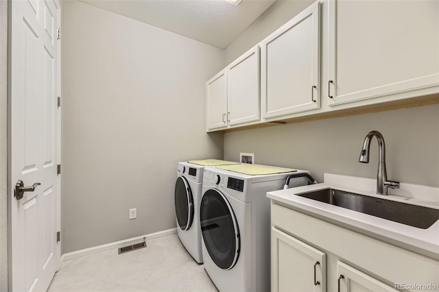 laundry room featuring sink, cabinets, a textured ceiling, and independent washer and dryer