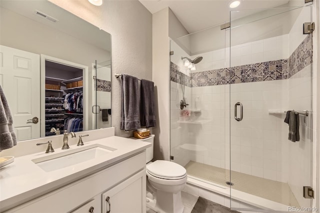 bathroom featuring vanity, toilet, and an enclosed shower