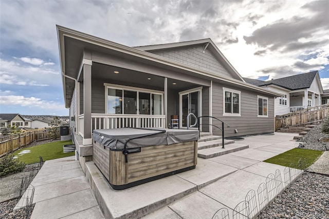 back of property with a patio area and a hot tub