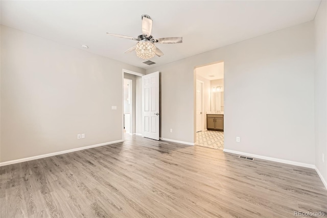 spare room with ceiling fan and light wood-type flooring