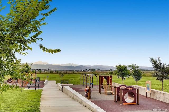 view of playground with a mountain view and a lawn