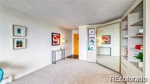 interior space featuring light carpet and a textured ceiling