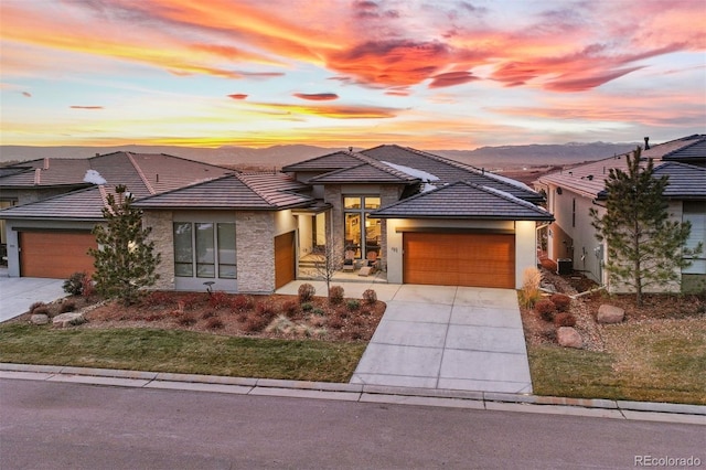 prairie-style house with a garage and a mountain view