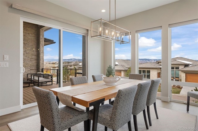 dining space with light hardwood / wood-style flooring and a chandelier