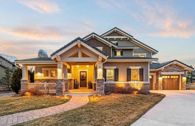 craftsman inspired home with a yard, a garage, and a porch