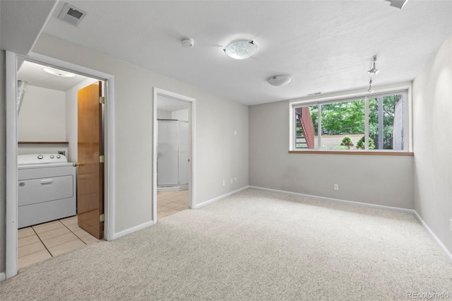 584 Ridgeview Dr, Louisville, CO 80027 - unfurnished bedroom with washer / clothes dryer, light carpet, baseboards, ensuite bathroom, and light tile patterned flooring