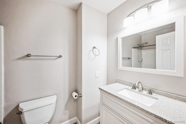 bathroom with a shower, vanity, and toilet