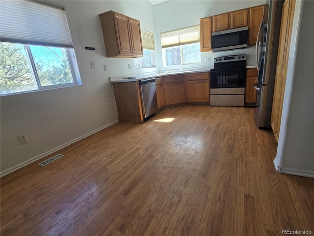 kitchen with plenty of natural light, visible vents, stainless steel appliances, and wood finished floors