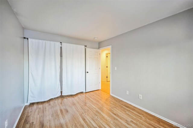 unfurnished bedroom with light wood-type flooring and baseboards