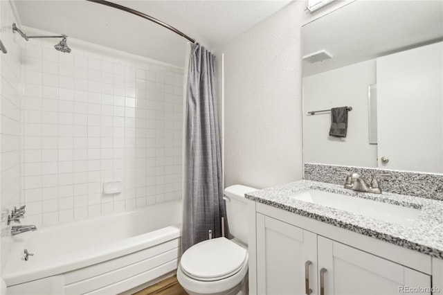 bathroom featuring visible vents, vanity, toilet, shower / tub combo with curtain, and a textured wall