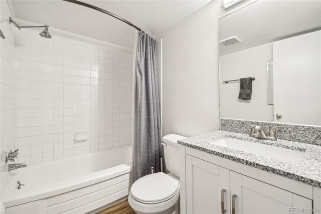 100 S Clarkson St Unit 304, Denver, CO 80209 - bathroom featuring visible vents, vanity, toilet, shower / tub combo with curtain, and a textured wall