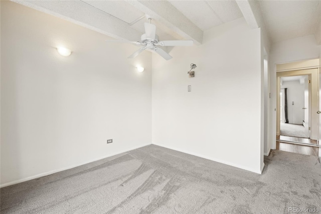 carpeted empty room with baseboards, a ceiling fan, and beam ceiling