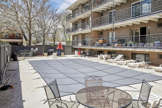 view of swimming pool featuring outdoor dining area, fence, a fenced in pool, and a patio