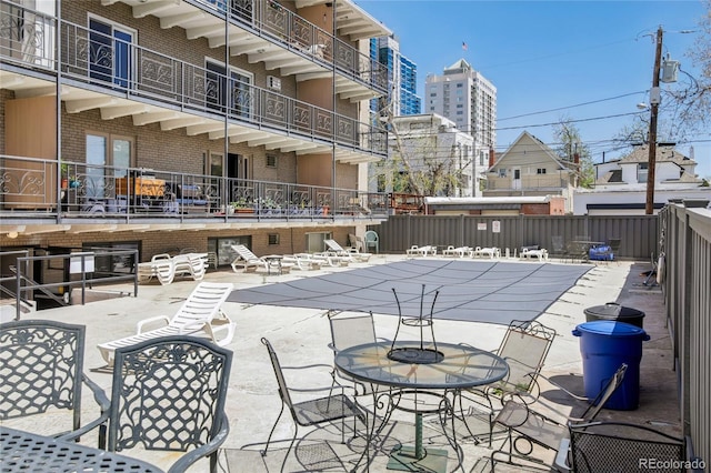 view of patio featuring a community pool and fence