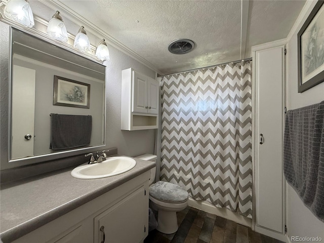 21300 County Road 13, La Jara, CO 81140 - bathroom featuring a textured ceiling, toilet, visible vents, crown molding, and vanity