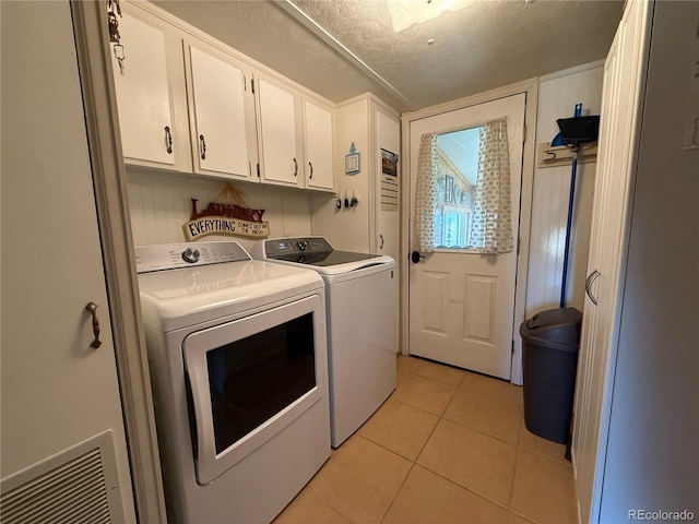 21300 County Road 13, La Jara, CO 81140 - laundry room with light tile patterned flooring, washer and dryer, a textured ceiling, and cabinet space