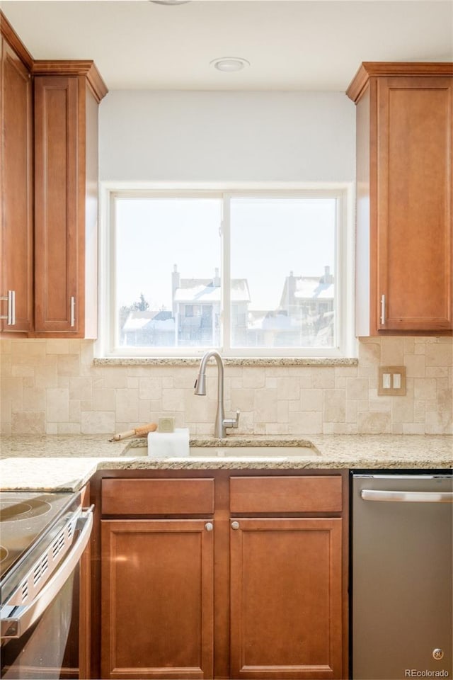 kitchen featuring dishwasher, sink, light stone countertops, and backsplash