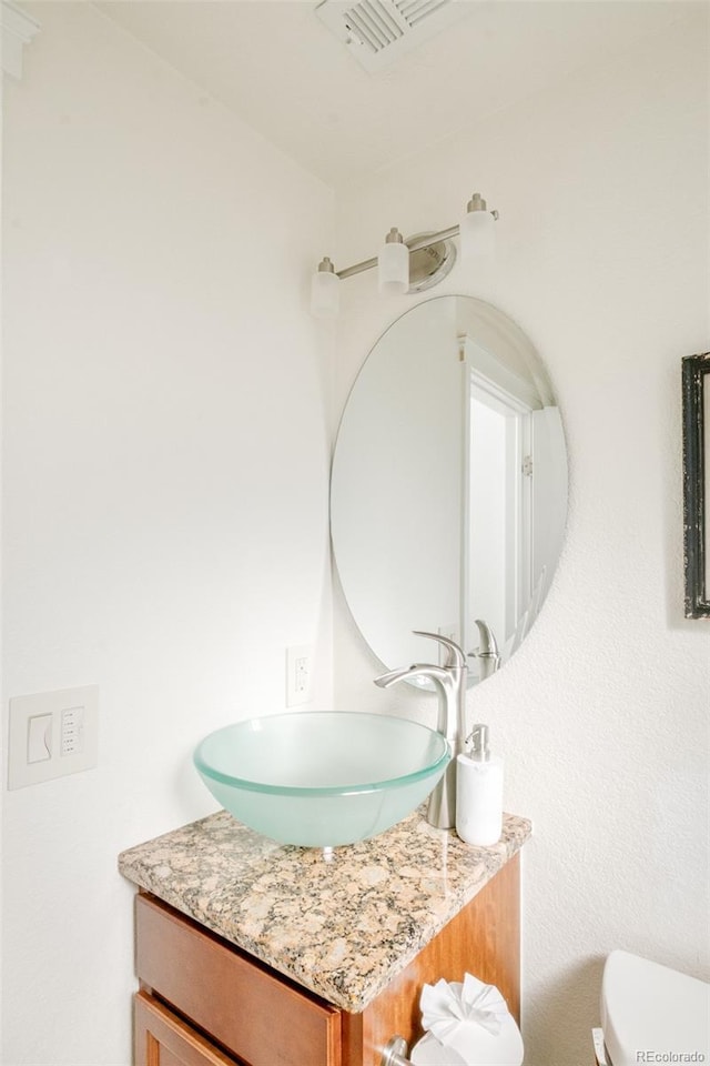 bathroom featuring vanity and toilet