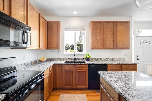 5861 Mt Shadows Blvd, Firestone, CO 80504 - kitchen featuring black appliances, a sink, light wood-style floors, light stone countertops, and recessed lighting